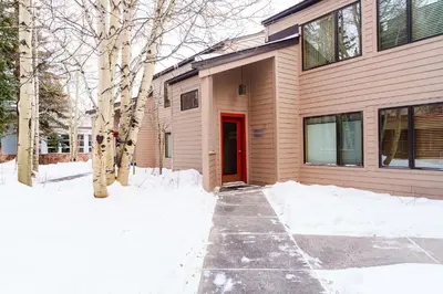 a house with a red door in the snow at 503 Ski Run condo in Keystone