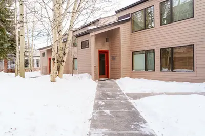 a house with a red door in the snow at 503 Ski Run condo in Keystone