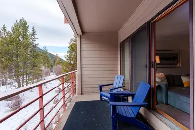 two blue chairs sitting on the porch of a house at 503 Ski Run condo in Keystone