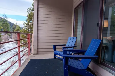 two blue chairs sitting on the front porch of a house at 503 Ski Run condo in Keystone