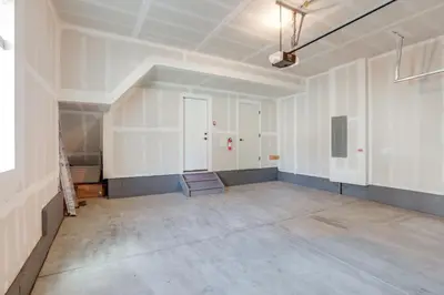 an empty room with white walls and concrete floors at Creekside Retreat Near Olde Town Arvada in Arvada