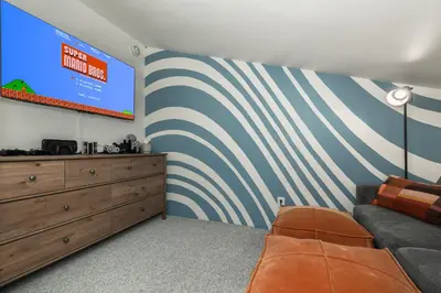 a living room with a couch and a large screen at Cozy Winter Park Ski & Bike Retreat in Winter Park