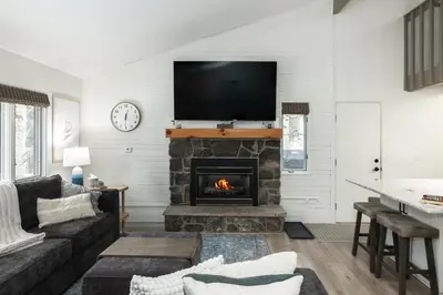 a living room with a fireplace with a tv above it at Cozy Winter Park Ski & Bike Retreat in Winter Park