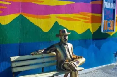 a statue of a man in a hat sitting on a bench at Wild Irishman 1029 - Keystone in Dillon