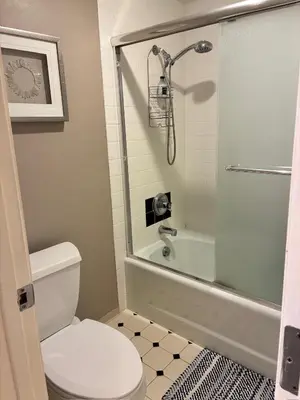 a bathroom with a shower and a toilet and a tub at 2BR Condo in Heart of LoDo with Great Amenities in Denver