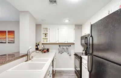 a kitchen with a sink and a refrigerator at 2BR Condo in Heart of LoDo with Great Amenities in Denver
