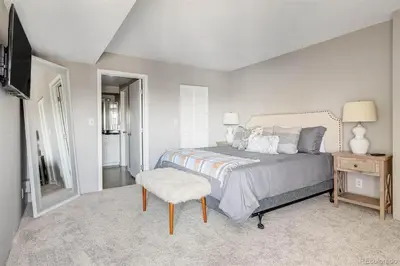 a bedroom with a bed and a chair and a television at 2BR Condo in Heart of LoDo with Great Amenities in Denver