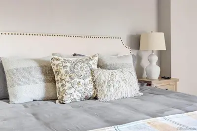 a bedroom with a bed with pillows and a lamp at 2BR Condo in Heart of LoDo with Great Amenities in Denver
