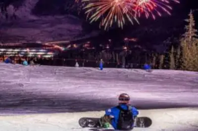 a person on a snowboard sitting in the snow with fireworks at Lakepoint 807C - Frisco in Frisco