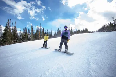 a man and a child on snowboards in the snow at Lakeshore 1535 in Keystone