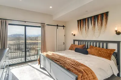 a bedroom with a large bed and a balcony at 4 Mi to Granby Ranch Gem with Balcony and Mtn Views! in Granby