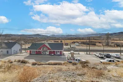 a red building with cars parked in a parking lot at 4 Mi to Granby Ranch Gem with Balcony and Mtn Views! in Granby