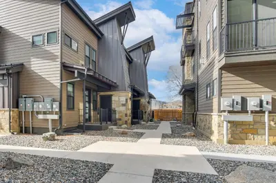a walkway between two buildings with parking meters at 4 Mi to Granby Ranch Gem with Balcony and Mtn Views! in Granby