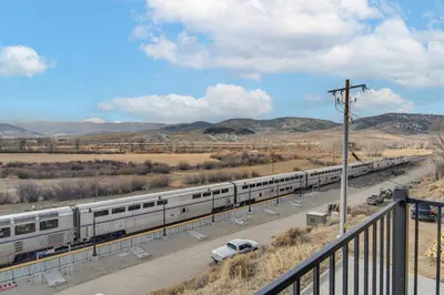 a train on the tracks in the middle of a road at 4 Mi to Granby Ranch Gem with Balcony and Mtn Views! in Granby