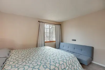 a bedroom with a bed and a blue couch at 3 Mi to Buckley Convenient Condo in Aurora in Aurora