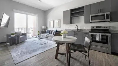 a kitchen and living room with a table and a kitchen and a couch at Landing Chic Studio in Fort Collins in Fort Collins
