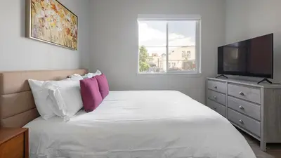 a bedroom with a bed with a television and a dresser at Landing Chic Studio in Fort Collins in Fort Collins