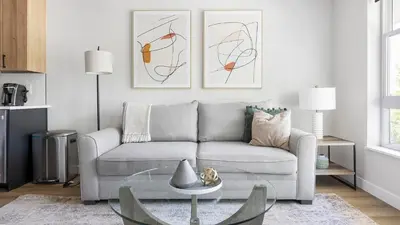 a living room with a couch and two paintings on the wall at Landing Stunning Studio Rooftop Lounge Gym in Englewood