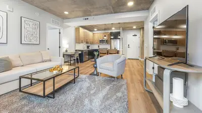 a living room with a couch and a table at Landing Stunning Studio Rooftop Lounge Gym in Englewood