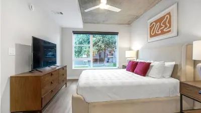 a bedroom with a large bed and a window at Landing Stunning Studio Rooftop Lounge Gym in Englewood