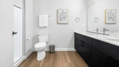 a white bathroom with a toilet and a sink at Landing Stunning Studio Rooftop Lounge Gym in Englewood
