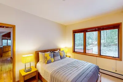 a bedroom with a bed and two windows at Tenmile Vista Retreat in Silverthorne