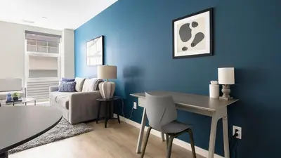 a blue living room with a table and a couch at Landing Beautiful 1BD Gym Rooftop Lounge in Denver