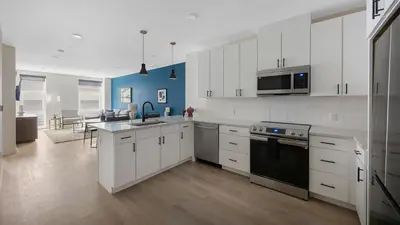 a kitchen with white cabinets and a black stove top oven at Landing Beautiful 1BD Gym Rooftop Lounge in Denver