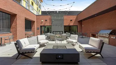 a patio with chairs and a table and a grill at Landing Beautiful 1BD Gym Rooftop Lounge in Denver