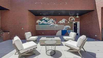 a patio with chairs and a table and a mural at Landing Beautiful 1BD Gym Rooftop Lounge in Denver