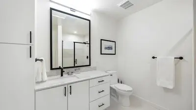 a white bathroom with a sink and a toilet at Landing Beautiful 1BD Gym Rooftop Lounge in Denver