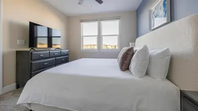 a bedroom with a white bed with a dresser and two windows at Landing Amazing 2BD Pool Clubhouse in Loveland