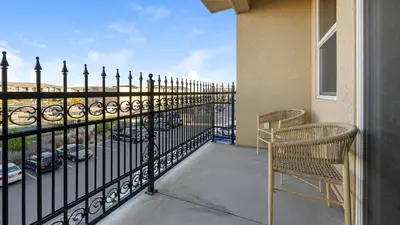 a balcony with two chairs and a fence at Landing Amazing 2BD Pool Clubhouse in Loveland