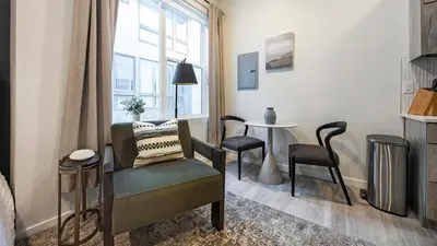 a living room with a chair and a table at Landing Modern Studio Rooftop Lounge in Denver