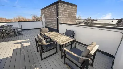 a wooden table and chairs on a balcony at Landing Modern Studio Rooftop Lounge in Denver
