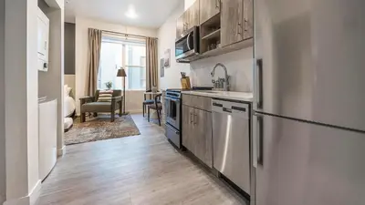 a kitchen with a refrigerator and a sink at Landing Modern Studio Rooftop Lounge in Denver