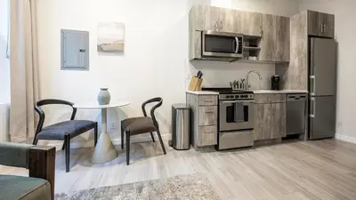 a kitchen with a stove and a table with chairs at Landing Modern Studio Rooftop Lounge in Denver