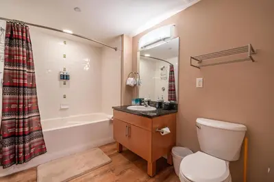 a bathroom with a tub and a toilet and a sink at Fraser Crossing 1BR Condo | Hot Tub Access + Walk to Lifts in Winter Park