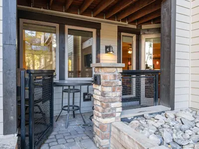a screened in porch with a table and a grill at Fraser Crossing 1BR Condo | Hot Tub Access + Walk to Lifts in Winter Park