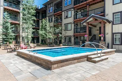 a swimming pool in front of a building at Fraser Crossing 1BR Condo | Hot Tub Access + Walk to Lifts in Winter Park