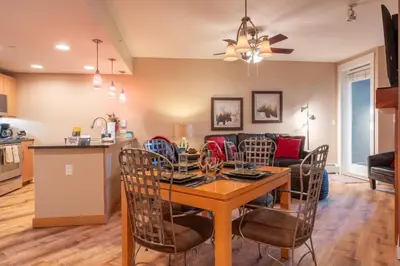 a kitchen and living room with a table and chairs at Fraser Crossing 1BR Condo | Hot Tub Access + Walk to Lifts in Winter Park