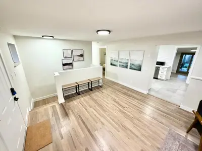 a living room with white walls and wooden floors at Family Fun Hub - Games, Hot Tub, Putting Greens in Centennial