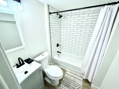 a white bathroom with a toilet and a sink at Family Fun Hub - Games, Hot Tub, Putting Greens in Centennial
