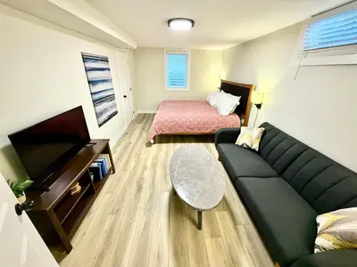 a living room with a couch and a bed at Family Fun Hub - Games, Hot Tub, Putting Greens in Centennial