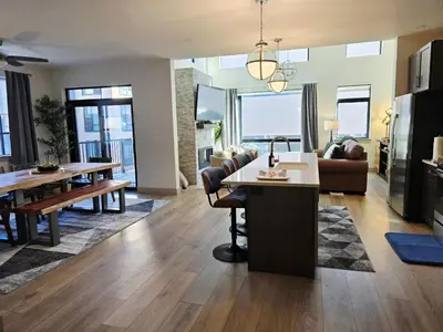 a living room with a kitchen and a dining room at 4th Street Alpine Loft - New - Central Ski Hub - King Bed, Garage Parking, Hot Tub, Great Location in Silverthorne