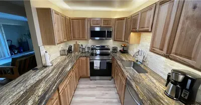 a kitchen with wooden cabinets and a black appliances at Summit Mountain Escape in Silverthorne