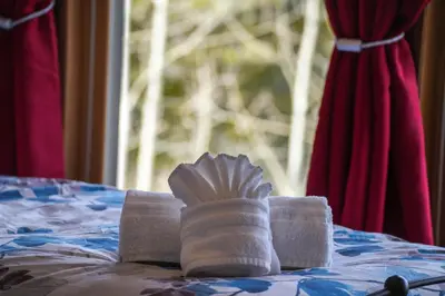 a pile of towels on a bed with a window at Scenic Colorado Stay Near Casinos & Hot Springs in Black Hawk