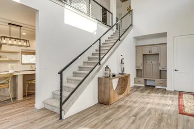 a staircase in a home with a kitchen and dining room at 1 Mi to Granby Ranch Luxe Home with Mtn Views! in Granby