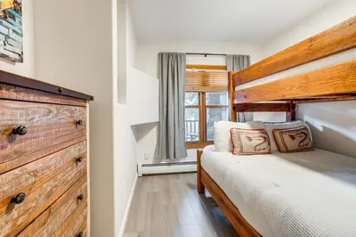 a bedroom with a bed and a wooden headboard at Walk to Ski Lift and Hot Tubs! Mtn-View Keystone Gem in Keystone