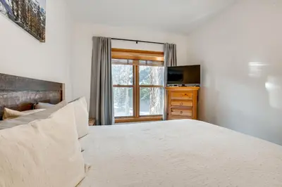 a bedroom with a large bed and a window at Walk to Ski Lift and Hot Tubs! Mtn-View Keystone Gem in Keystone